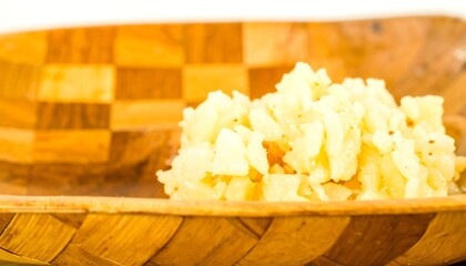 Small pile of light yellow food in a wooden bowl