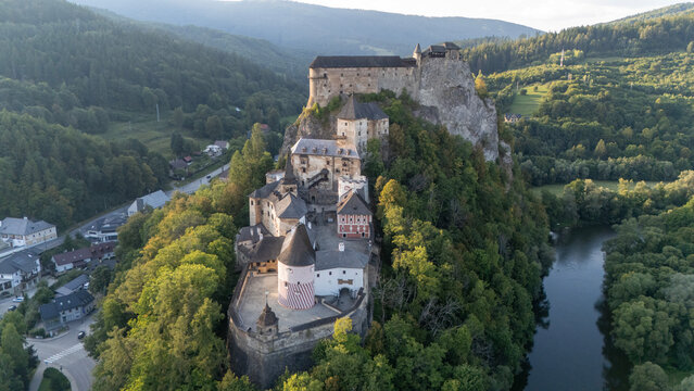 Orava Castle perched on dramatic cliffs above the Orava River in Slovakia. Sunset light reveals medieval architecture and breathtaking landscape. Ideal for history and travel visuals