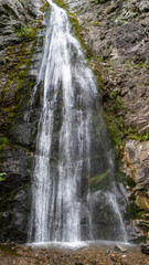 Naklejka premium Aerial view of Sutovsky waterfall cascading through lush forest in Mala Fatra National Park, Slovakia. Majestic nature scene in Europe, perfect for travel, documentary and environmental projects