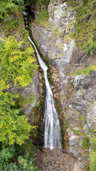 Aerial view of Sutovsky waterfall cascading through lush forest in Mala Fatra National Park, Slovakia. Majestic nature scene in Europe, perfect for travel, documentary and environmental projects