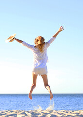 Fototapeta premium the girl is jumping against the sea.. Vertical photo format