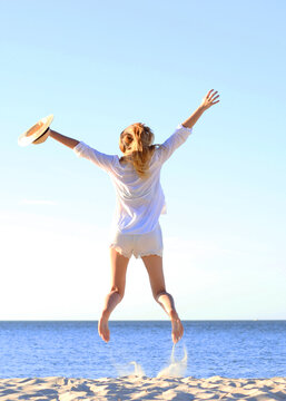 the girl is jumping against the sea.. Vertical photo format