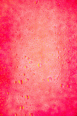beautiful background background dense with golden drops of water on glass and stains, gentle feminine pink berry red scarlet bright neon color and shade for girls and young women