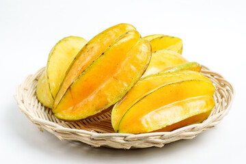 Fresh ripe starfruit (carambola) arranged in a natural woven basket on clean white background, tropical exotic fruit concept for healthy organic lifestyle.