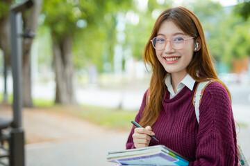  Study of portraits and female students at a university park to learn or study, scholarship books and laptops.