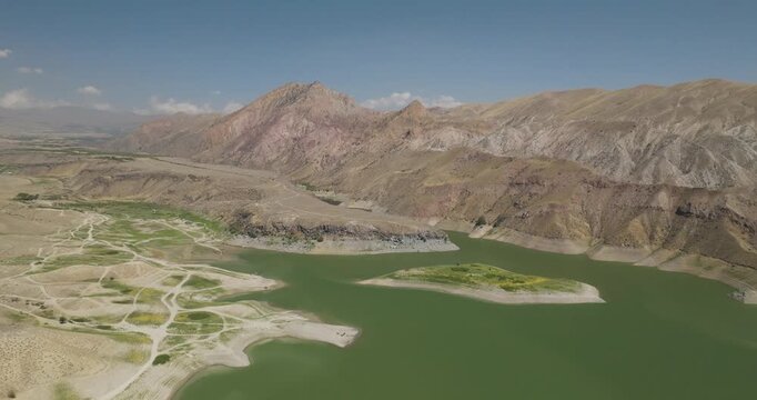 Aerial view of the beautiful Azat Reservoir, the serene green lake contrasting with the arid, mountainous landscape, Ararat Province, Armenia.