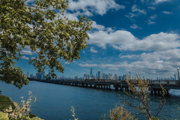 Waterfront view of New York with pathway and trees in foreground