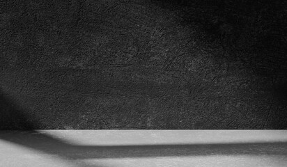 Dark light gray background with cement wall texture. Minimalist abstract background for product presentation with soft shadows from the window.