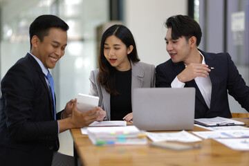 Group businesspeople happy while collaborating on a new project in an office. Businessman leading a discussion during a meeting with colleagues. Businesswoman interacting with a colleague.