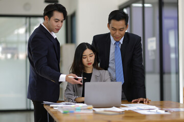Business meeting, brainstorming colleagues are discussing, planning a business project together on the computer.