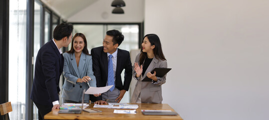 Coworkers standing and talking in the office.