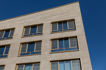 Modern brick building with large windows and smooth geometric lines.