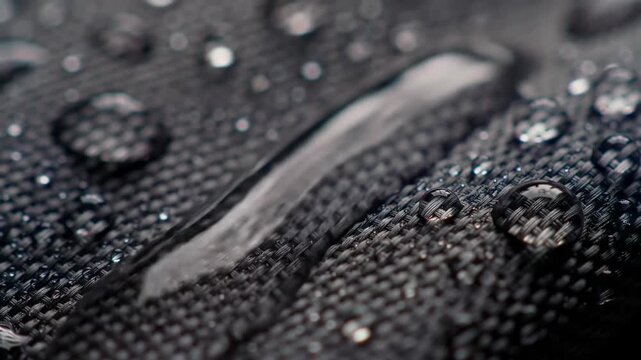 Water Resistant Fabric Texture: Macro Photography of Water Droplets on Dark Textile