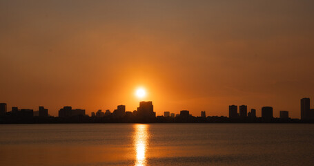 Golden sunset over the lake, silhouetted friends watching the glowing horizon in peaceful harmony.