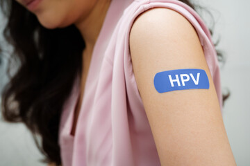 HPV, Human papilloma virus, Asian young woman receiving vaccine with blue bandage.