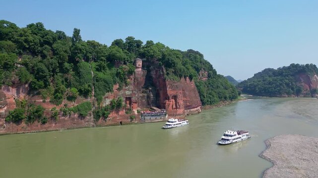 Leshan, China: Aerial drone footage of the famous Leshan giant Buddha stone statue  at the confluence of the Min River and Dadu River in Sichuan in China. Shot with an forward motion