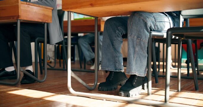 Legs, anxiety and students in classroom, nervous and exam stress with education, restless and learning. Feet, school and teenager with knowledge, test and studying with adhd, worry or academic growth