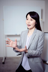 ホワイトボードの前でインタビューに答える女性20