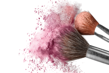Makeup powder explosion with brushes.  Pink blush or eyeshadow powder clouds around two makeup brushes
