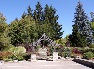 Summer landscape of the park with trees and arch