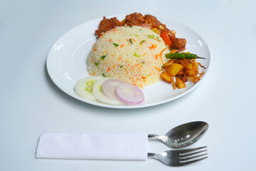 Authentic Asian Fried Rice Served with Devil Chicken on White Plate with spoon, fork