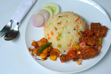 Delicious Fried Rice with Devil Chicken and Fresh Vegetables on White Plate with spoon, fork