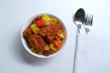 Authentic Sri Lankan Devil Chicken Curry in White Bowl with Utensils.