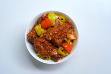 Sri Lankan Style Devil Chicken Served Hot in White Bowl. Top view.