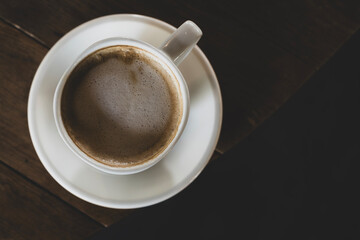 Hot latte coffee in white cup. Cappuccino style latte on table. Cup of latte with frothy milk. Freshly brewed latte with milk foam.