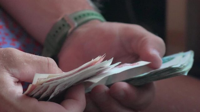 Money counting hands, man counting cash rubles indoors for payment or savings