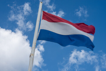 Netherlands flag waving on a cloudy day: dutch national symbol of freedom and pride