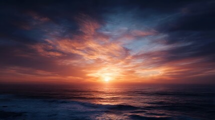 Obraz premium Vibrant orange and blue hues paint the sky above a tranquil ocean at sunset creating a breathtaking and serene natural landscape