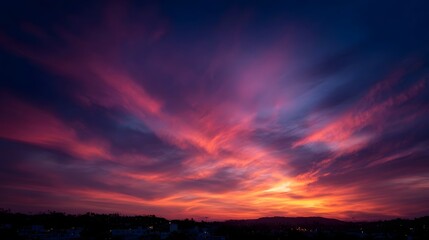 Fototapeta premium Vibrant pink and orange clouds paint the twilight sky creating a breathtaking and dramatic natural spectacle over a dark horizon