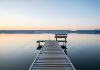 Obraz premium Calm lake scene with wooden pier and bench at sunset with soft pastel colors