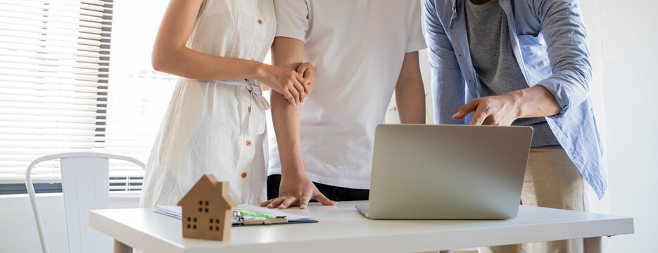A couple receives the keys from the owner of a housing development. Concept: A couple reaches an agreement to sign a contract to buy a house for their future.