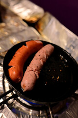 鉄のフライパンで焼くソーセージ