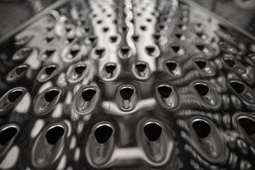 Close-up of a metallic grater or textured metal surface.