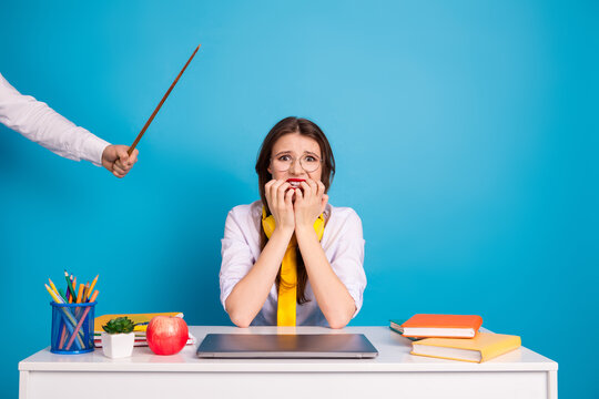 Stressed female student at desk with academic supplies in a retro-inspired style on a blue background