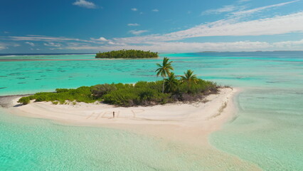 Aerial drone image of a castaway writing help in the sand while standing on a beautiful tropical island in the maldives