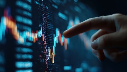 A finger points at a complex financial chart on a computer screen