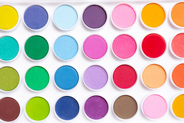 Vibrant watercolor paint set with diverse color palette in circular pots