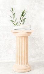Elegant Beige Column with White Towel and Olive Branches on Light Gray Background