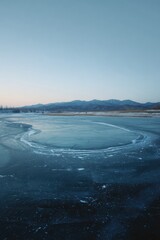 Frozen lake at dawn.  Distant mountains