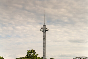 Obraz premium Observation tower stands tall against a cloudy sky in a serene outdoor setting near a river