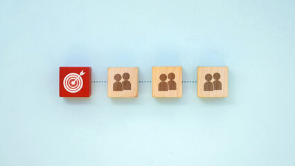 Target audience concept with wooden blocks showing people icons and marketing goal symbol
