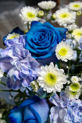 Close-up of a decorative flower composition with blue roses, daisies and soft petals, perfect for wedding or celebration background