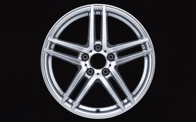 Obraz premium Sleek silver alloy car wheel rim with a modern five-spoke design, isolated on a black background, perfect for automotive concepts.