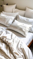 Soft, white bedding draped over a bed, highlighting the comforting, restful ambiance of a bedroom.