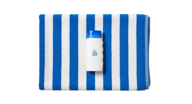 Overhead shot of spf lotion on a blue and white striped beach towel ready for summer vacation fun