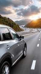 Fototapeta premium Hands grip the steering wheel of a car navigating a winding mountain road as the sun sets, casting beautiful hues over the scenery